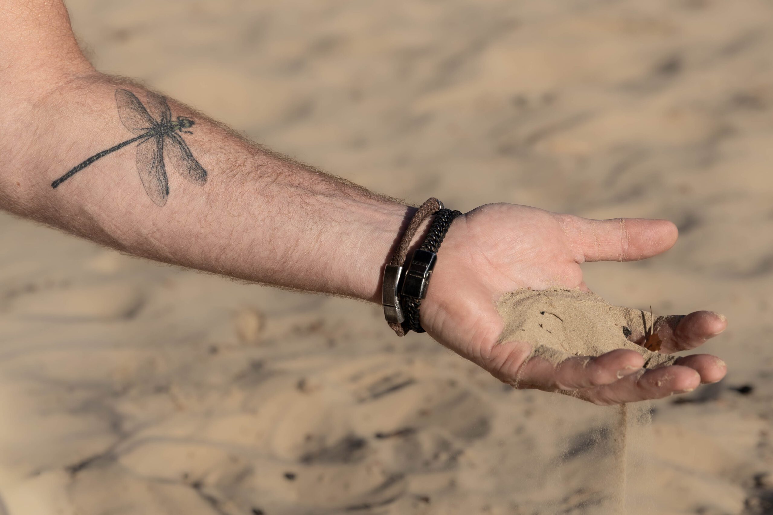 Zand dat door een hand glijdt, beeld bij de DATO-filosofie over organisatieverandering