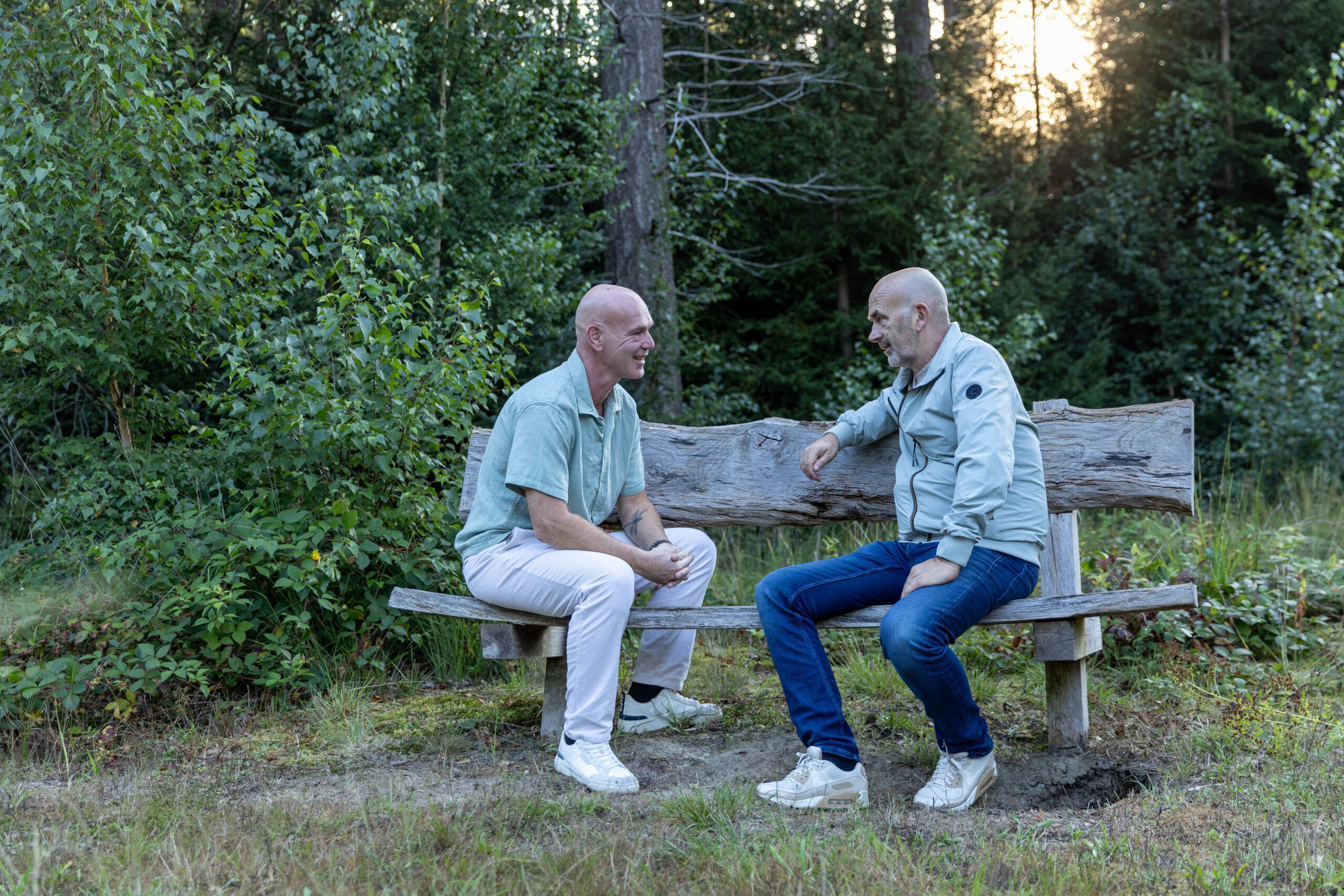 Coachend leiderschap: twee mensen in gesprek op een bankje buiten